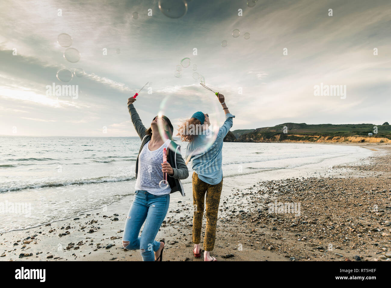 Happy friends making soap bubbles on the  beach Stock Photo