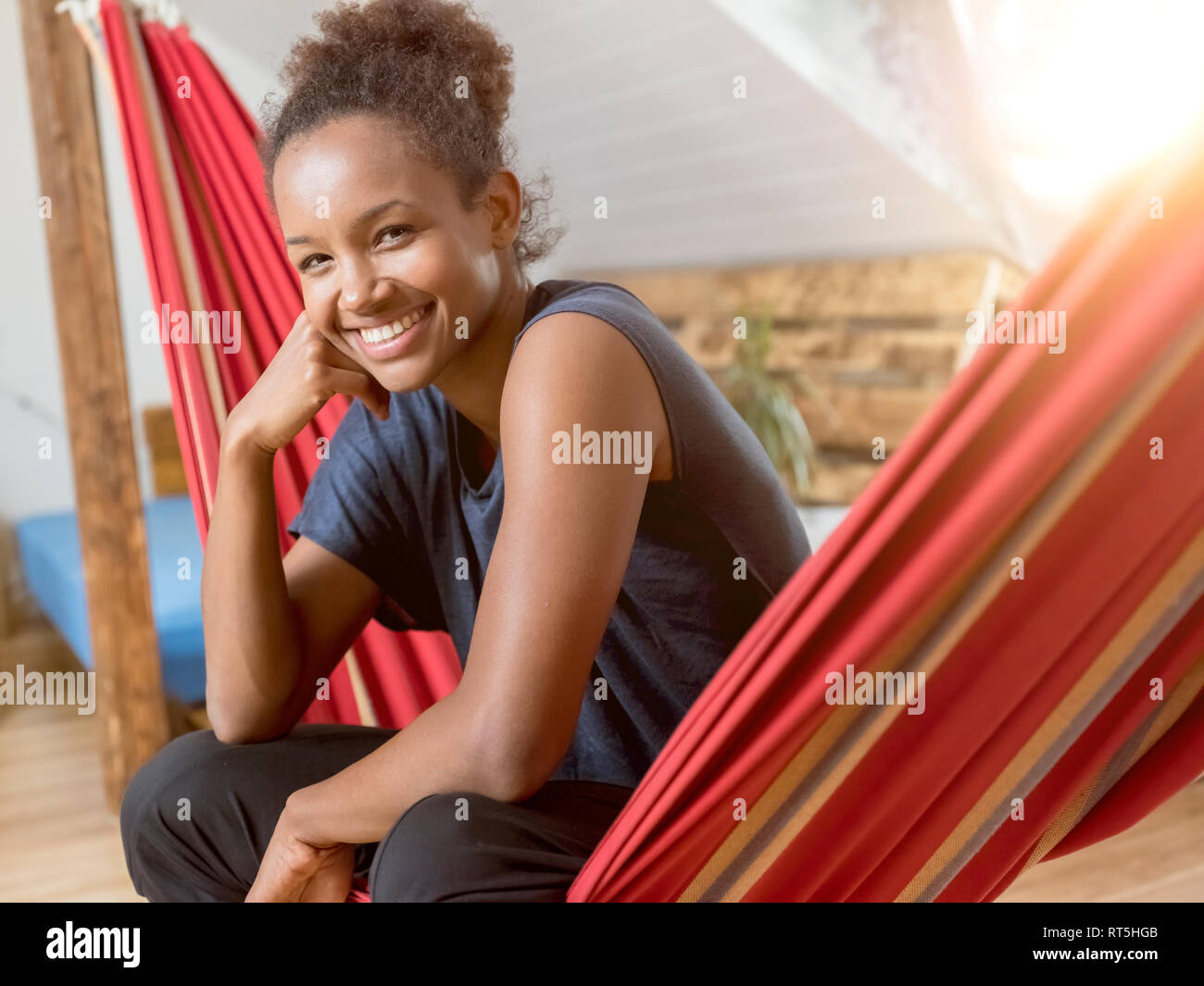 Portrait of happy young woman sitting in hammock Stock Photo