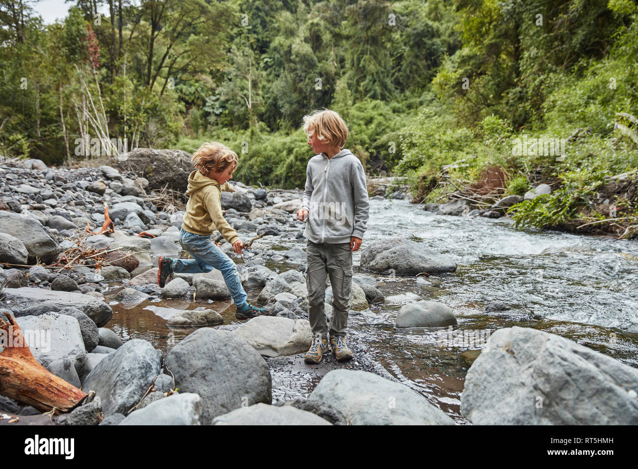 Chile, Patagonia, Osorno Volcano, Las Cascadas waterfall, two boys playing at a river Stock Photo
