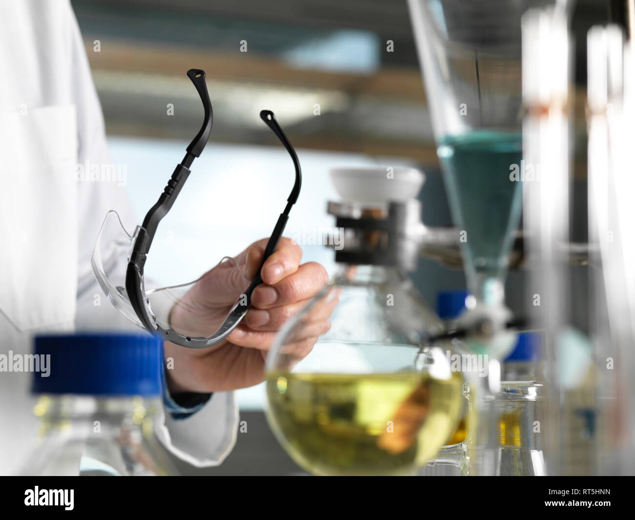 Scientist holding safety glasses during an experiment in the laboratory