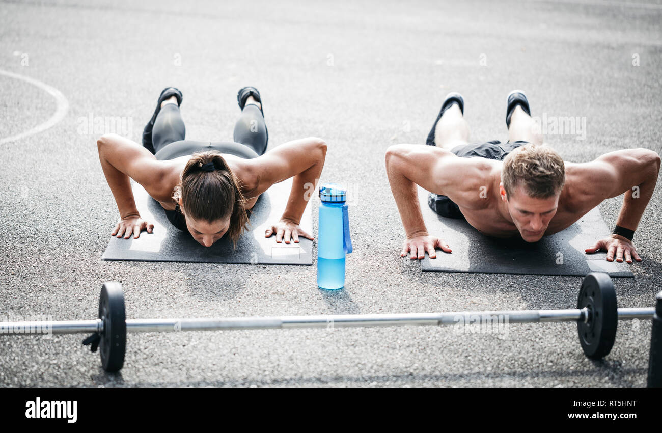 Sportive man and woman during pushups Stock Photo