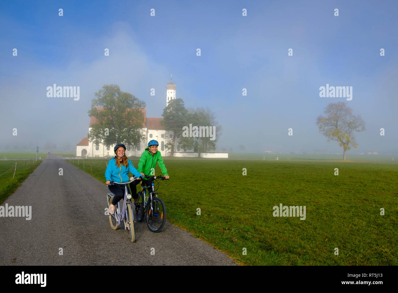 Germany, Pilgrimage Church St. Coloman and couple of cyclists on tour Stock Photo