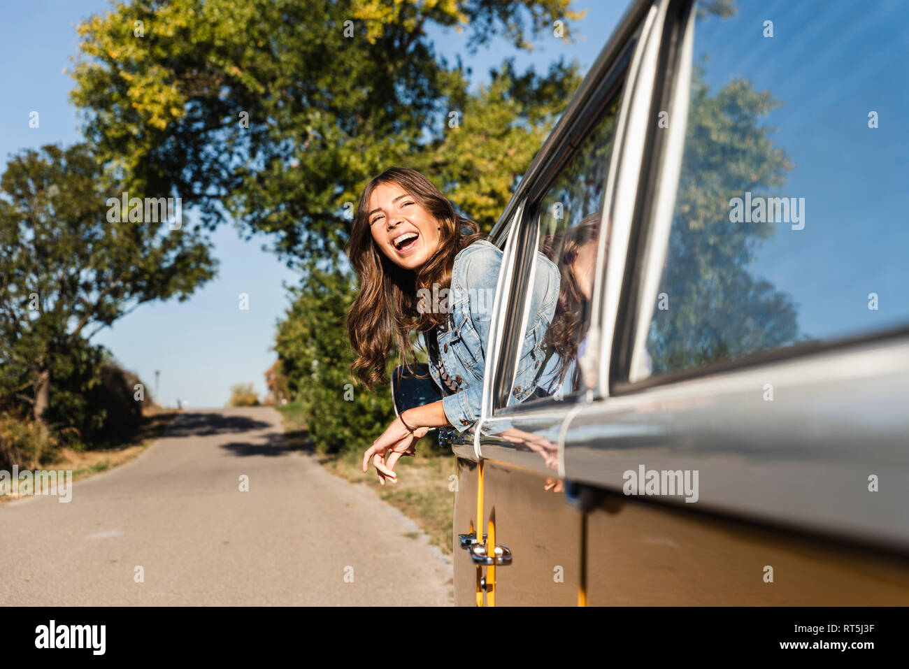 Pretty woman on a road trip with her camper, looking out of car window ...