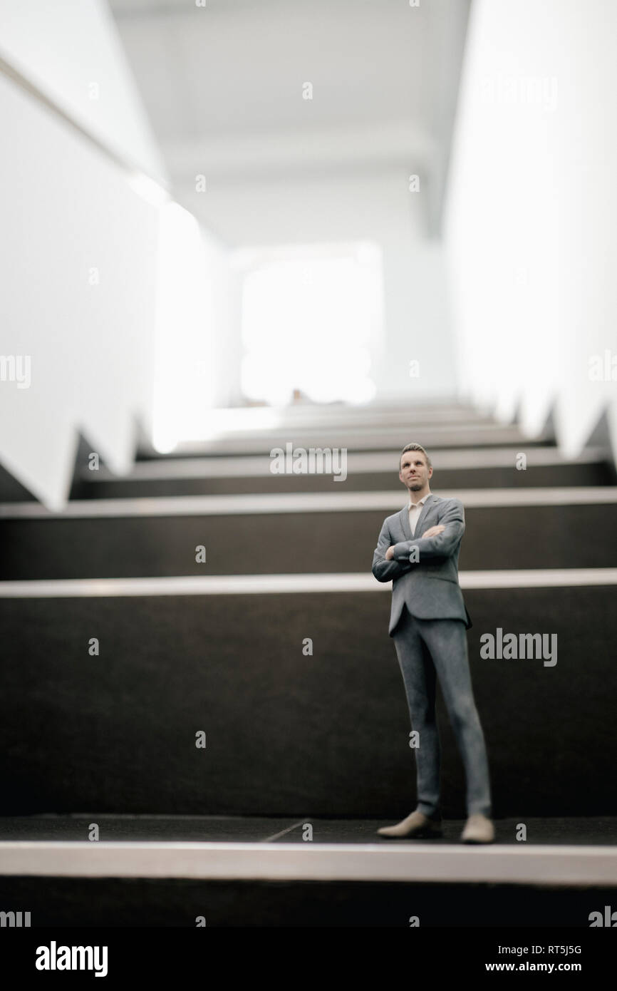 Businessman figurine standing on stairs in office Stock Photo