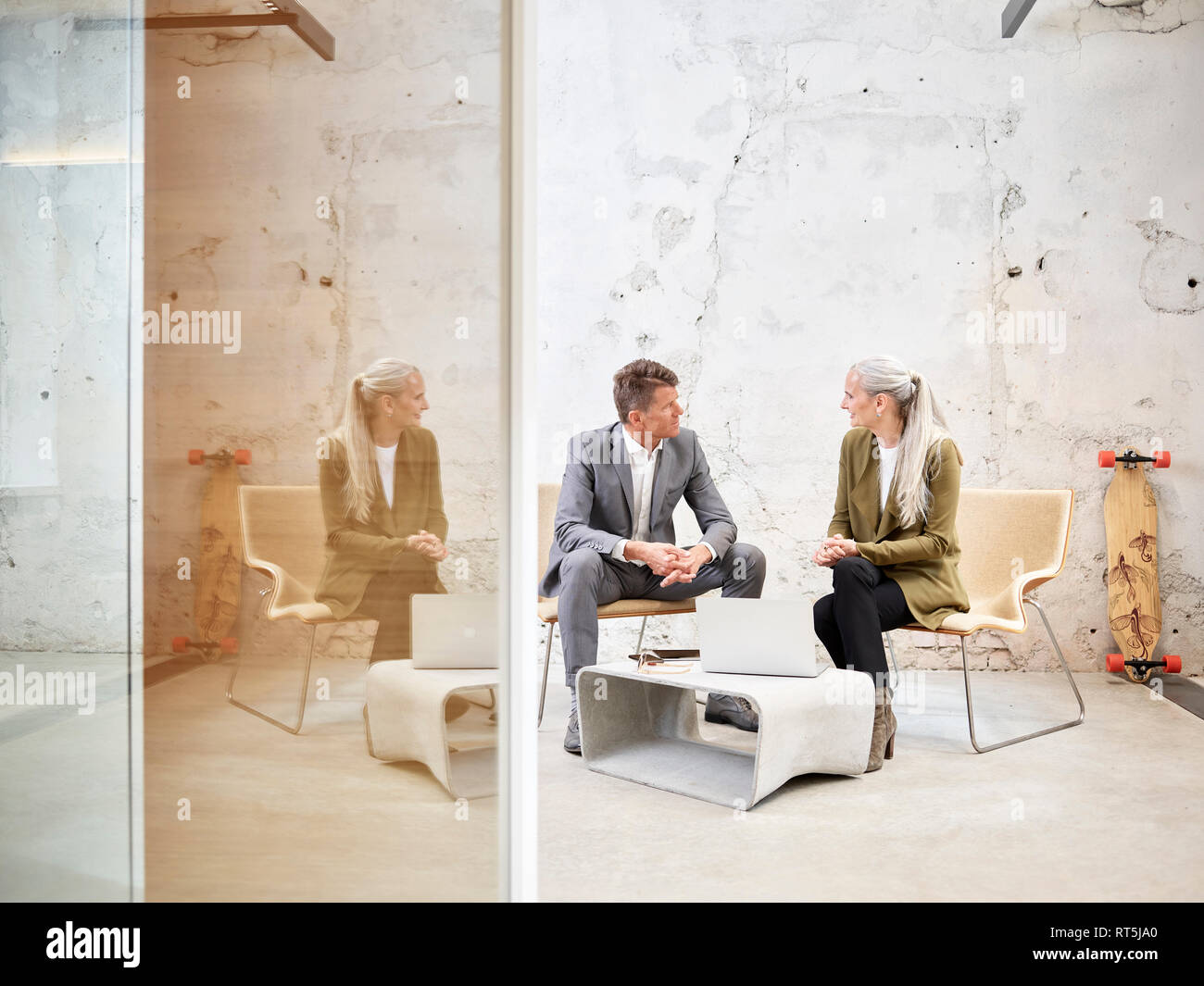 Businessman and businesswoman talking in modern office Stock Photo