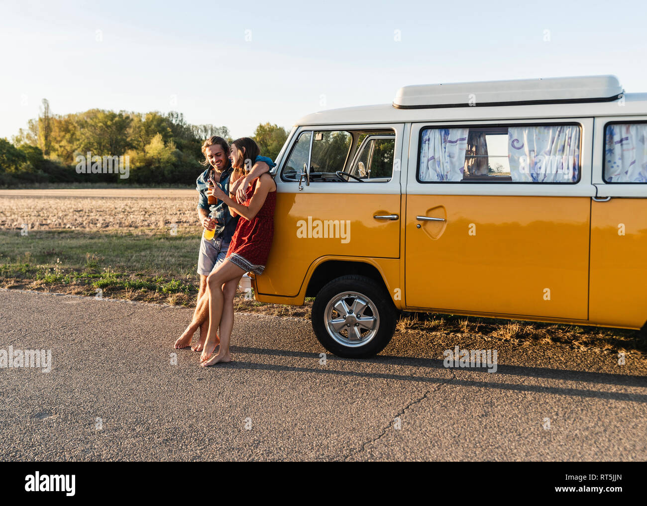 Happy couple taking a break on their road trip, having a drink Stock Photo