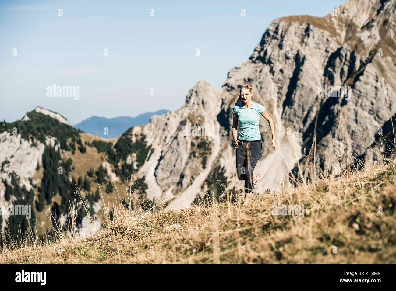 Austria, Tyrol, woman running in the mountains Stock Photo