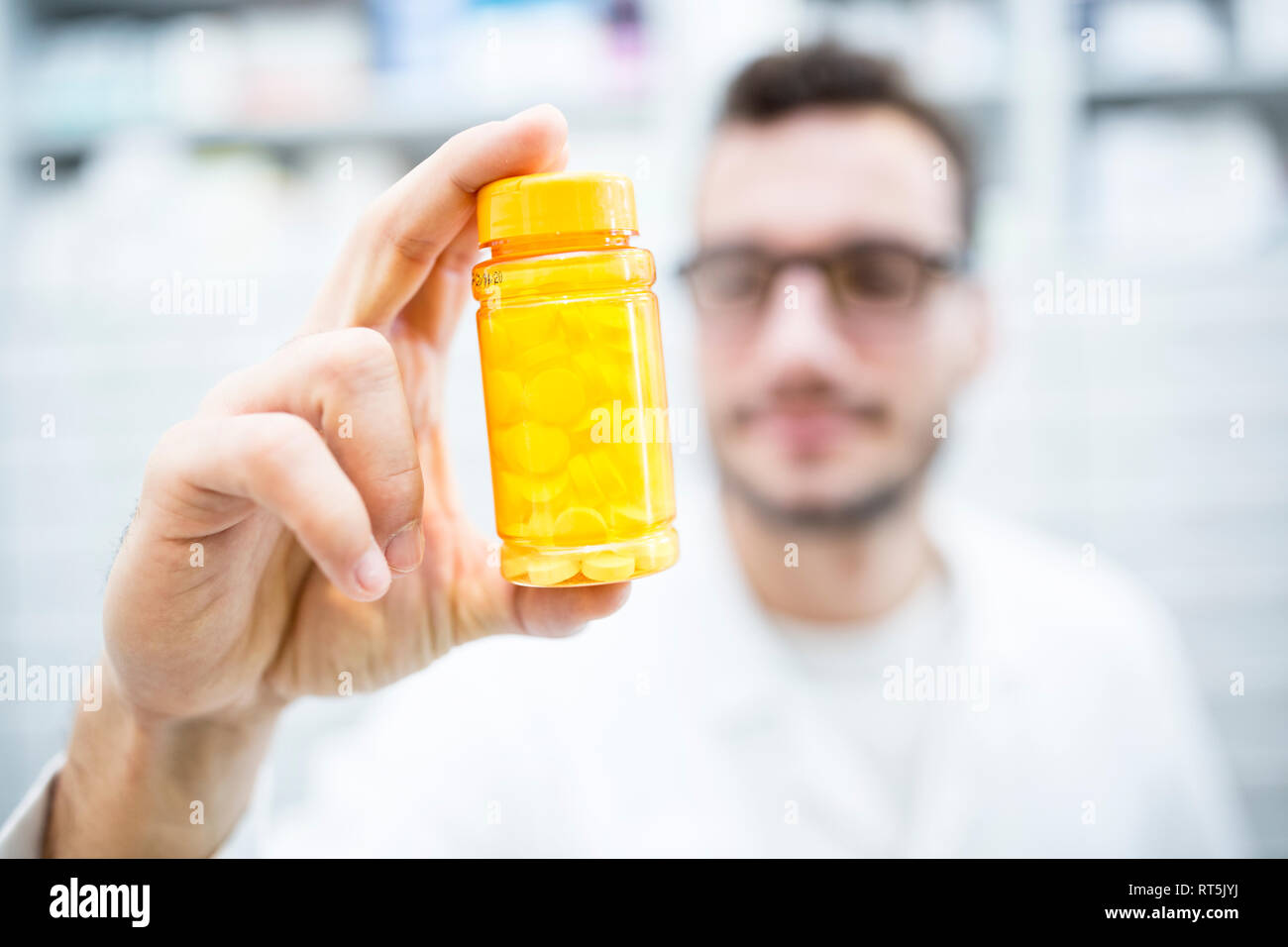 Close-up of pharmacist holding pill box in pharmacy Stock Photo