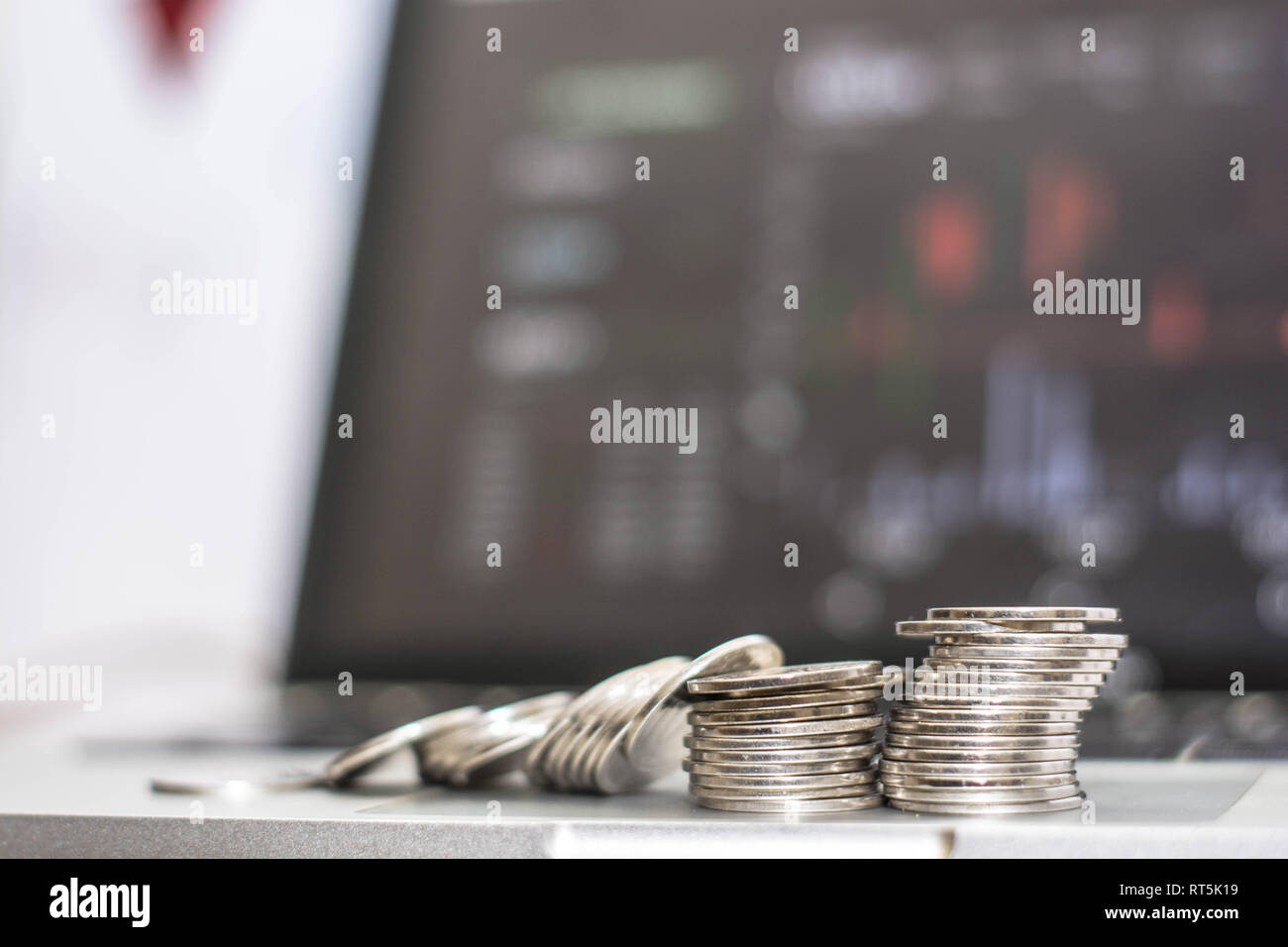 silver coin up scale concept, down scale coin in front of monitor screen showing trafic at trade exchange Stock Photo