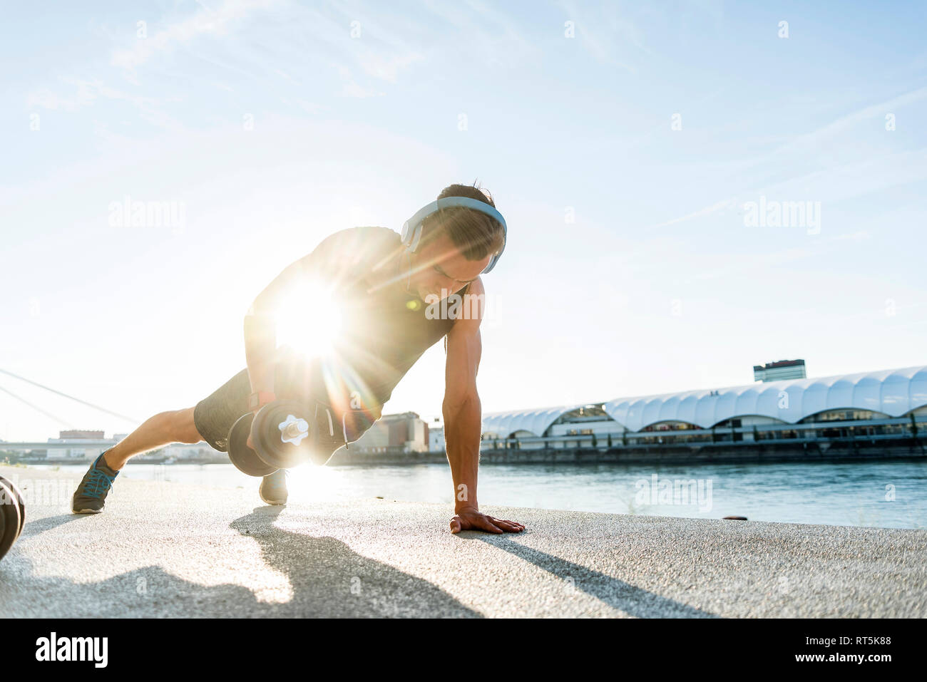 Fit athlete doing push ups at the river Stock Photo