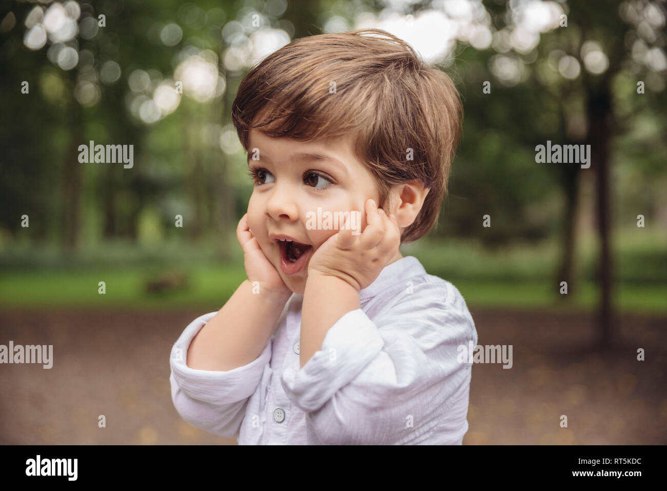 Toddler making surprised face in park Stock Photo