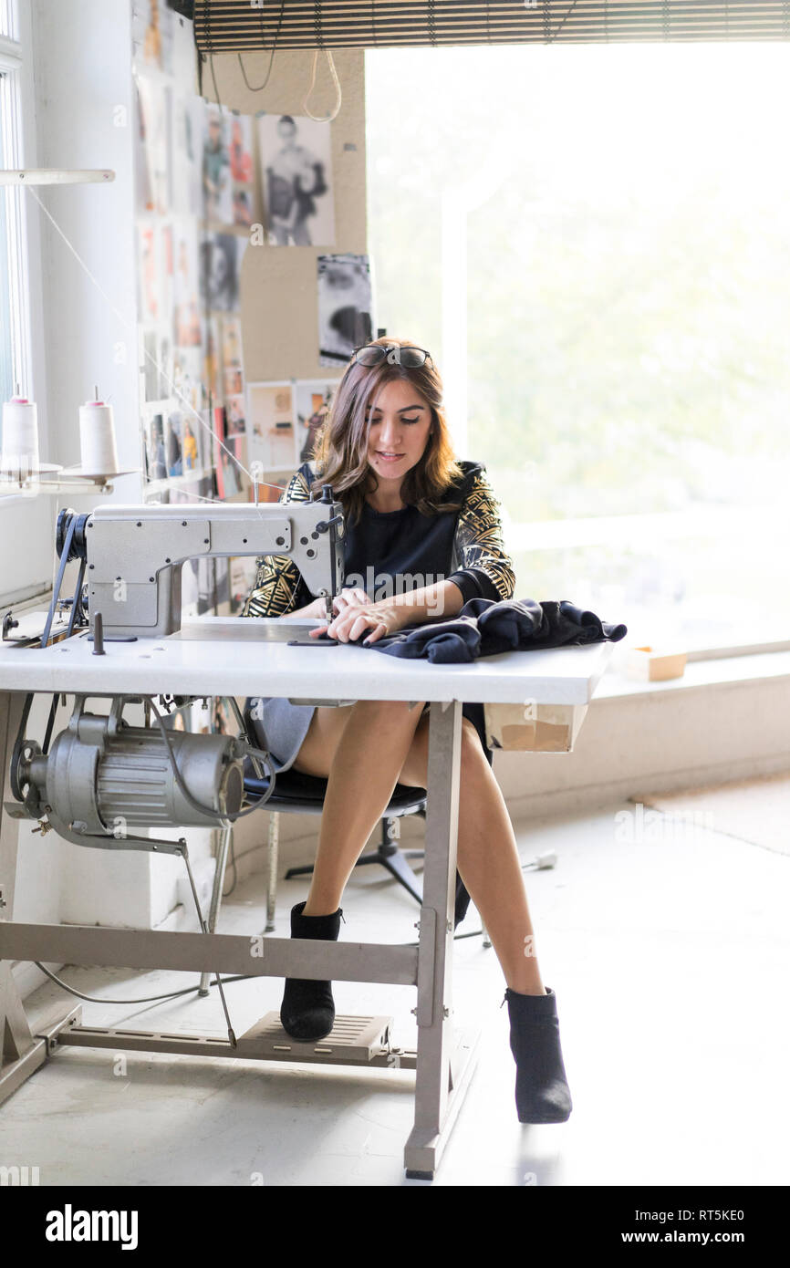 Young designer using sewing machine in an atelier Stock Photo