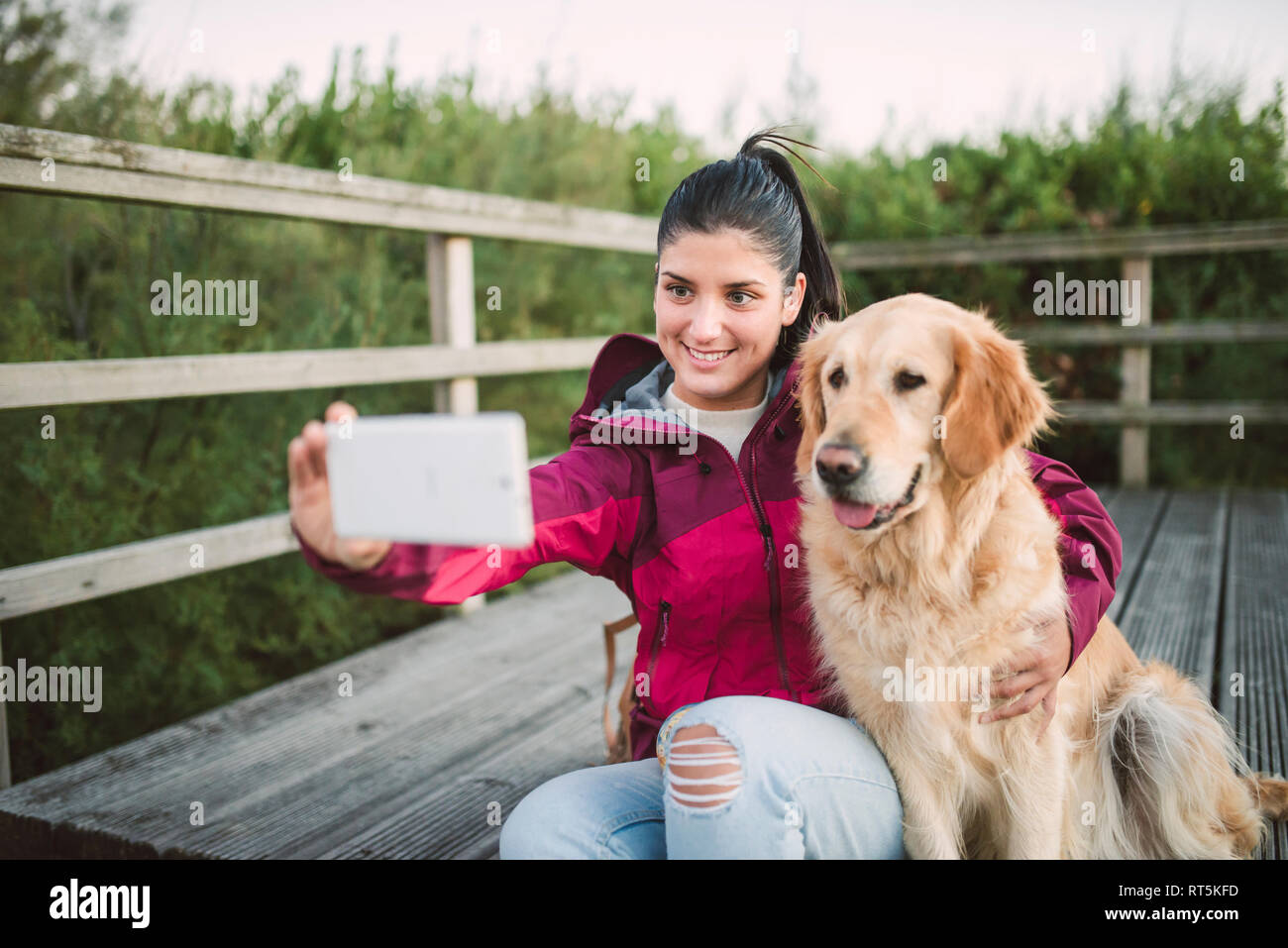 Smiling young woman taking a selfie with her dog Stock Photo - Alamy