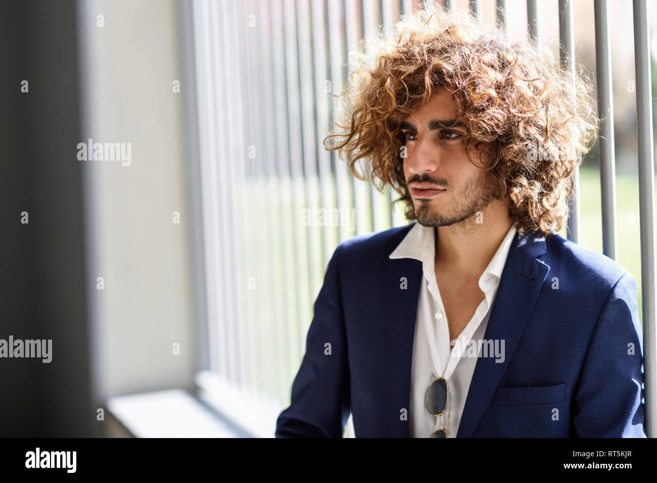 Portrait of young fashionable man with beard and curly hair Stock Photo
