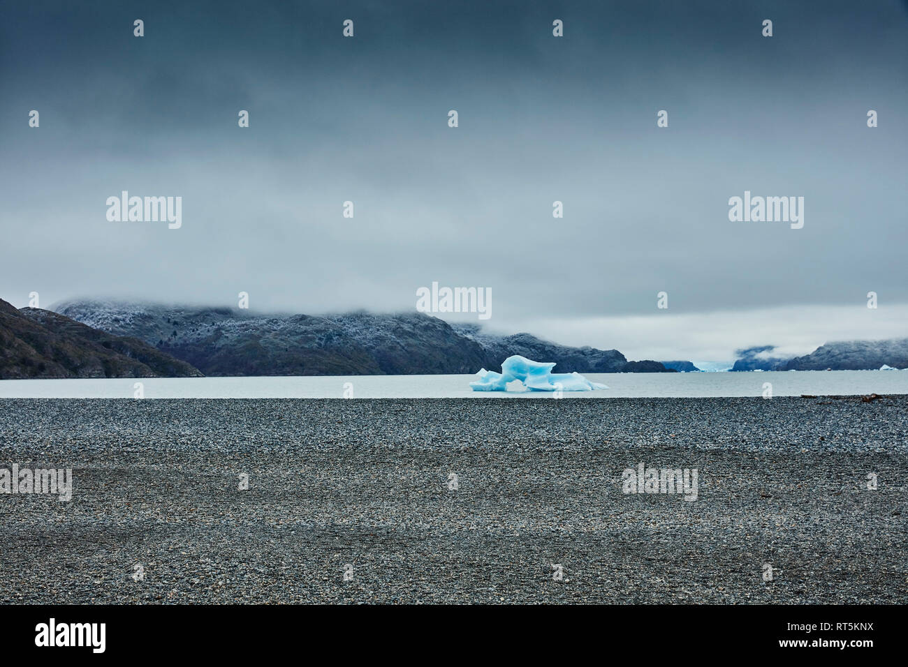 Chile, Torres del Paine National park, Lago Grey, stony shore and iceberg in water Stock Photo