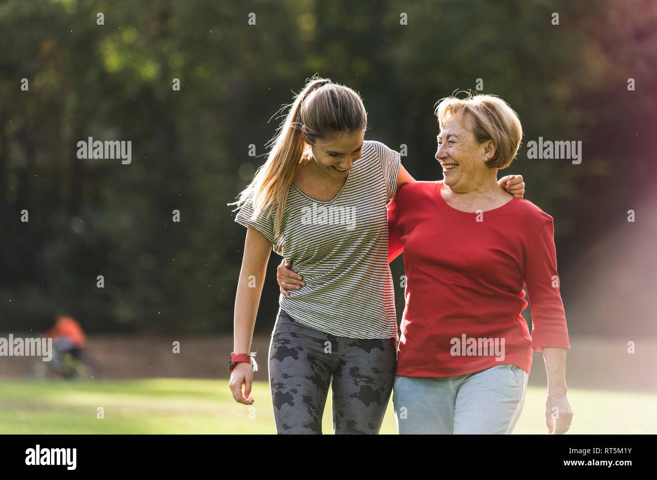 Granddaughter and grandmother having fun, jogging together in the park Stock Photo