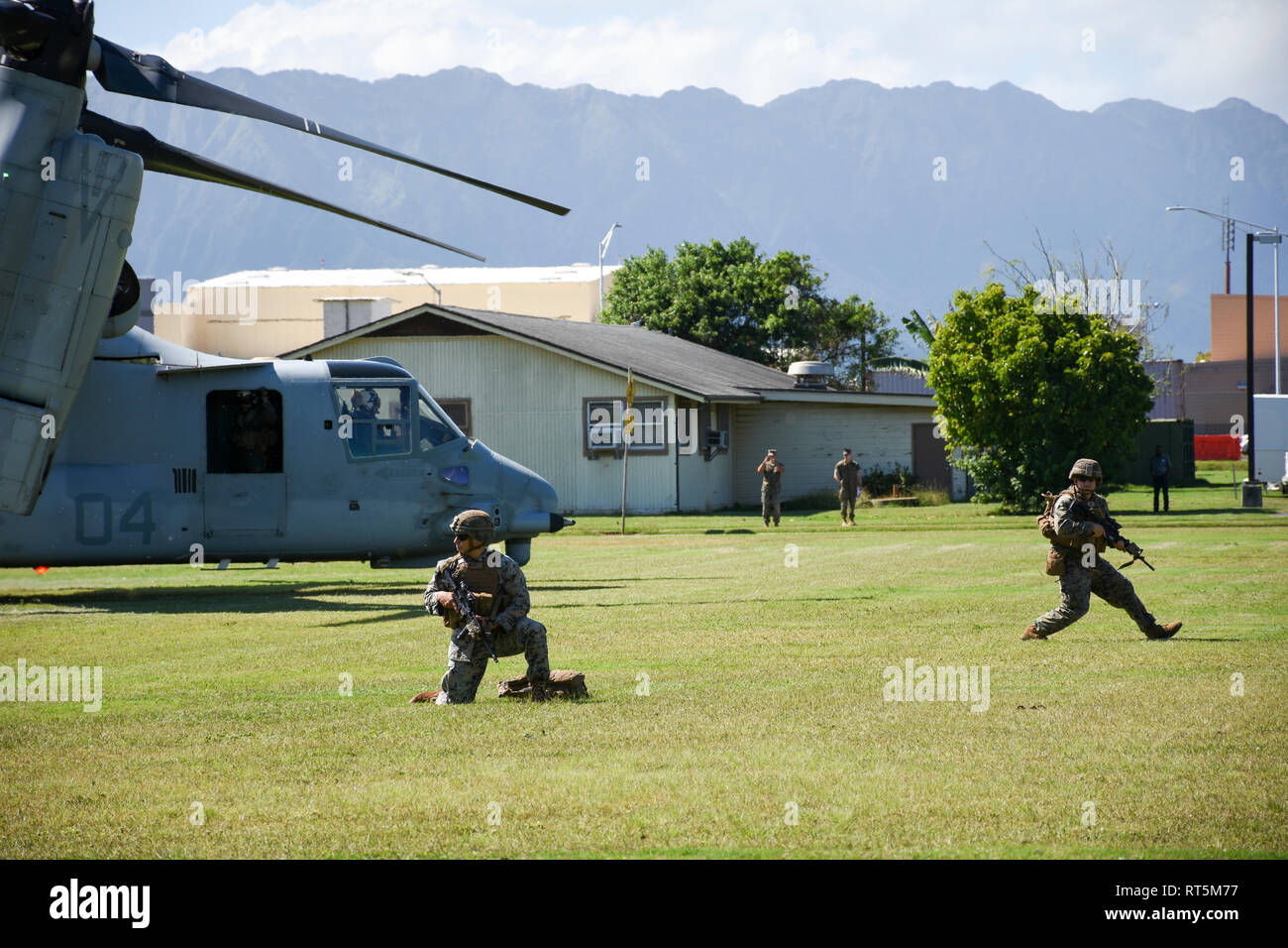 U.S. Marines with Weapons Company, 2nd Battalion, 3rd Marine Regiment set up a security perimeter after an MV-22B Osprey tiltrotor helicopter with Marine Medium Tiltrotor Squadron 268 drops them off at Landing Zone 216 to recover a simulated downed aircraft pilot during combat search and rescue training at Marine Corps Base Hawaii, Feb. 26, 2019. The CSAR training enhanced joint service crisis response capabilities to include locating, communicating, providing medical attention and recovering the isolated member. (U.S. Air Force photo by Tech. Sgt. Bob Jennings) Stock Photo