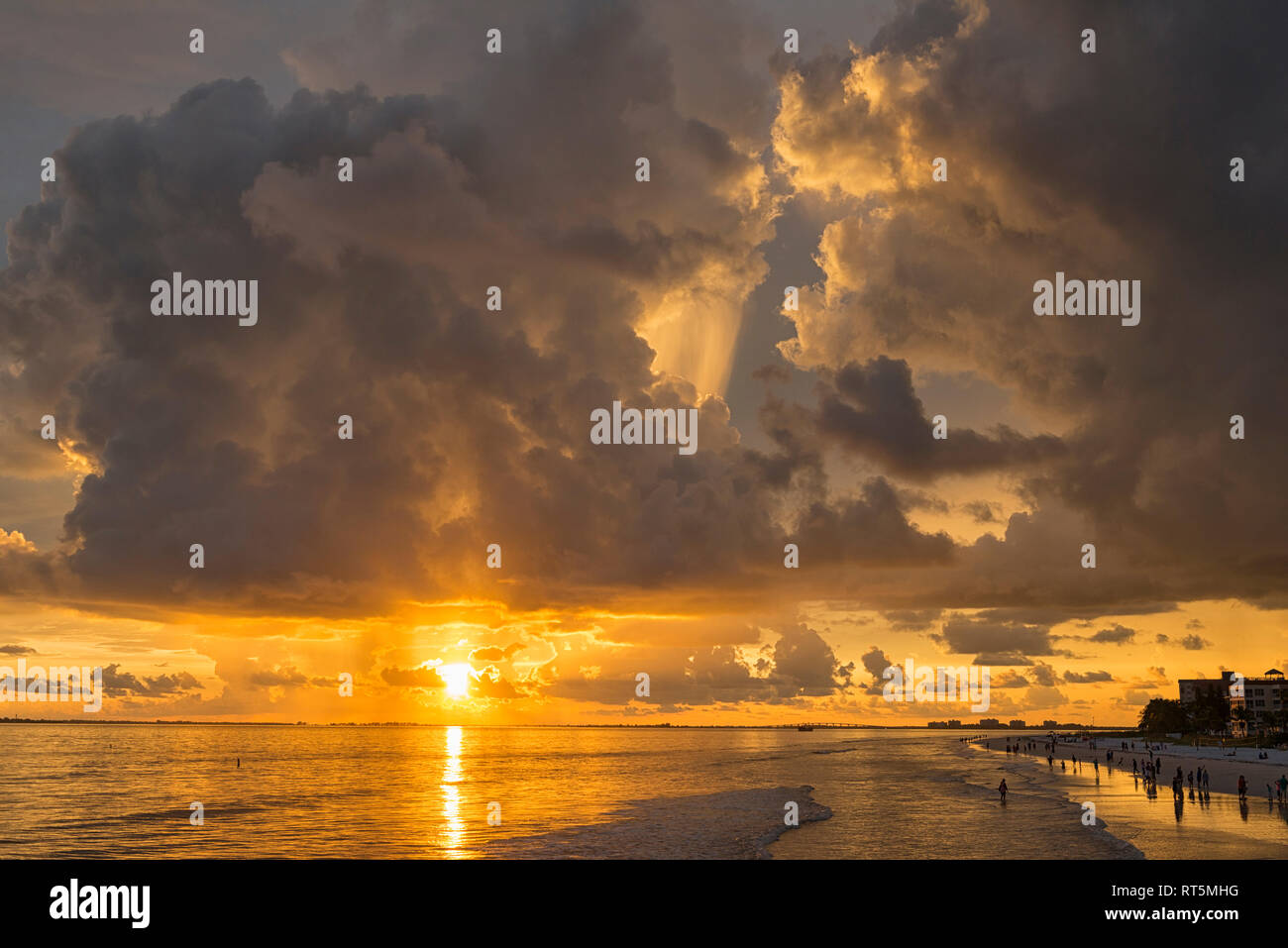 United States of America, Florida,  Fort Myers, silhouettes of Fort Myers Beach and tourists with a huge rain cloud above during sunset Stock Photo