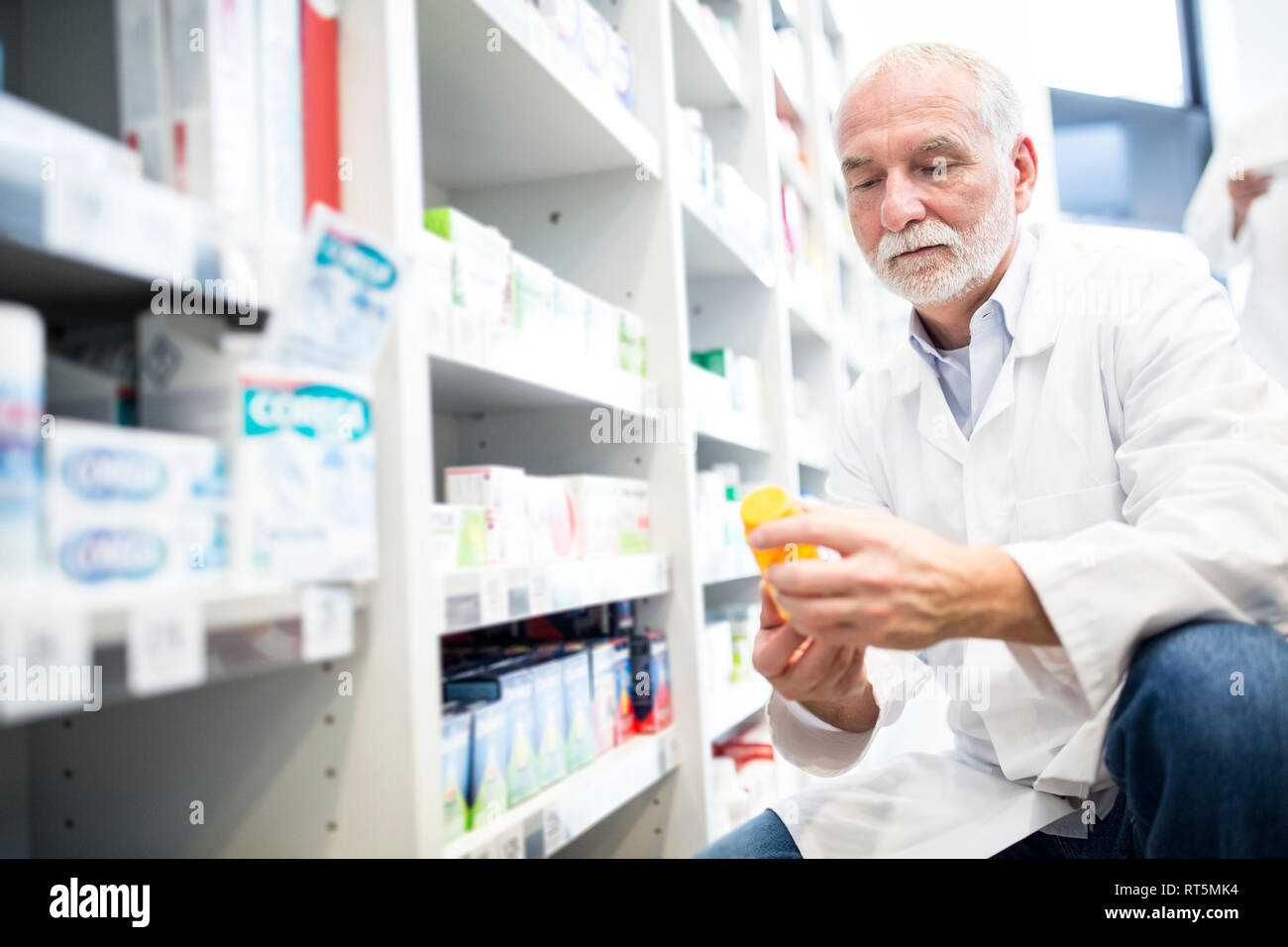 Pharmacist examining pill box in pharmacy Stock Photo