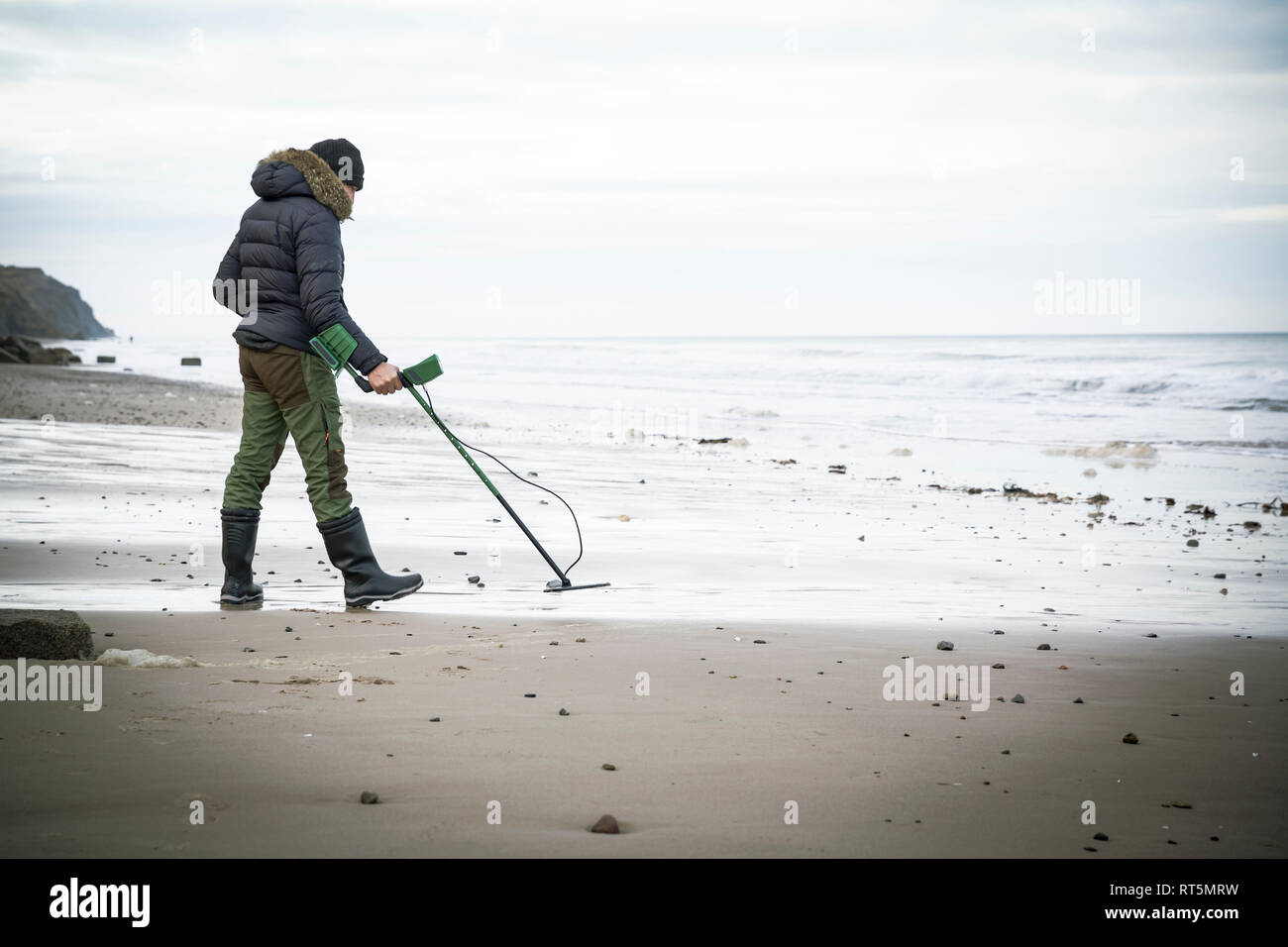 Man with metal detector at the sand beach Stock Photo