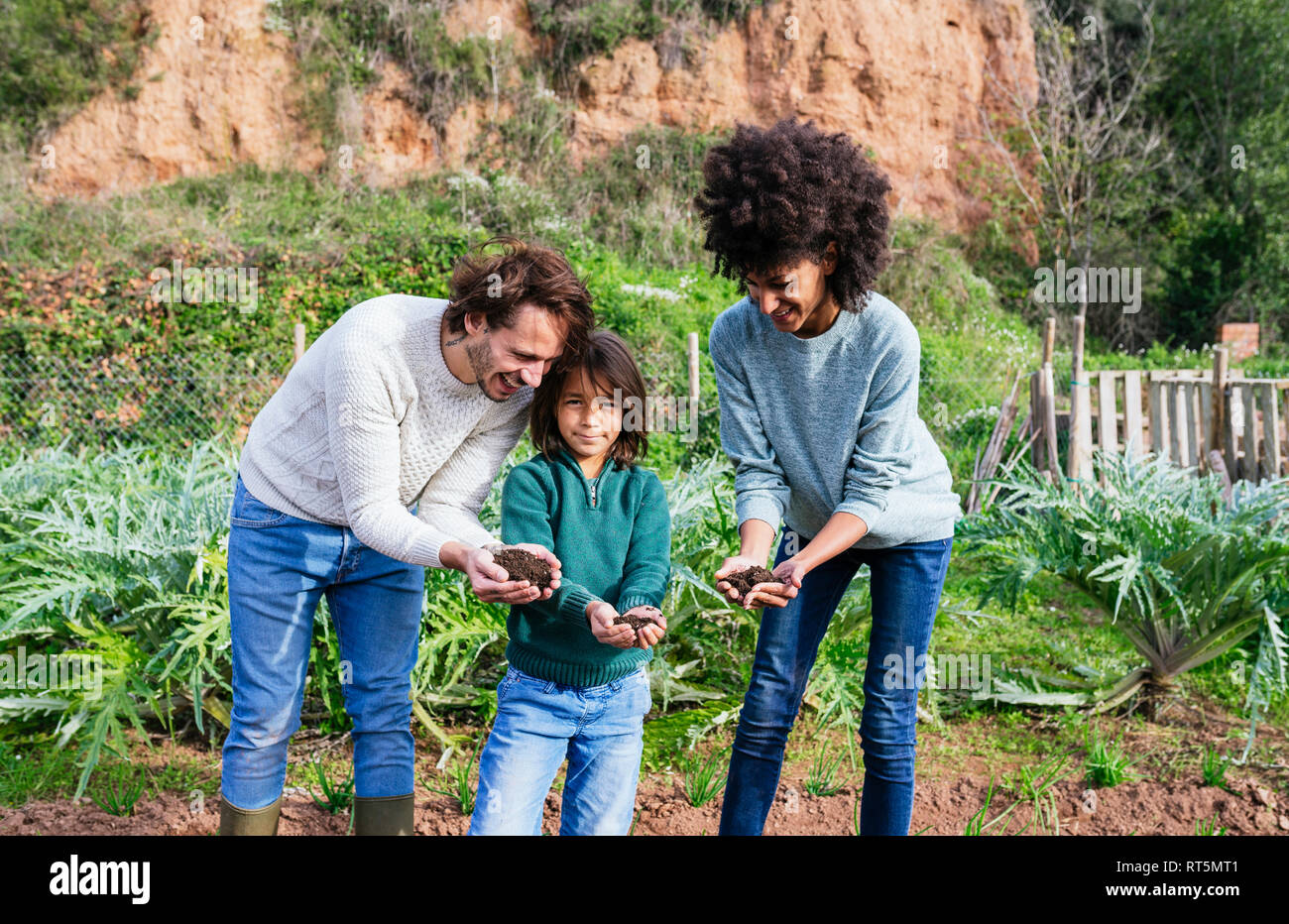 hapy family holding soil in their cupped hands Stock Photo