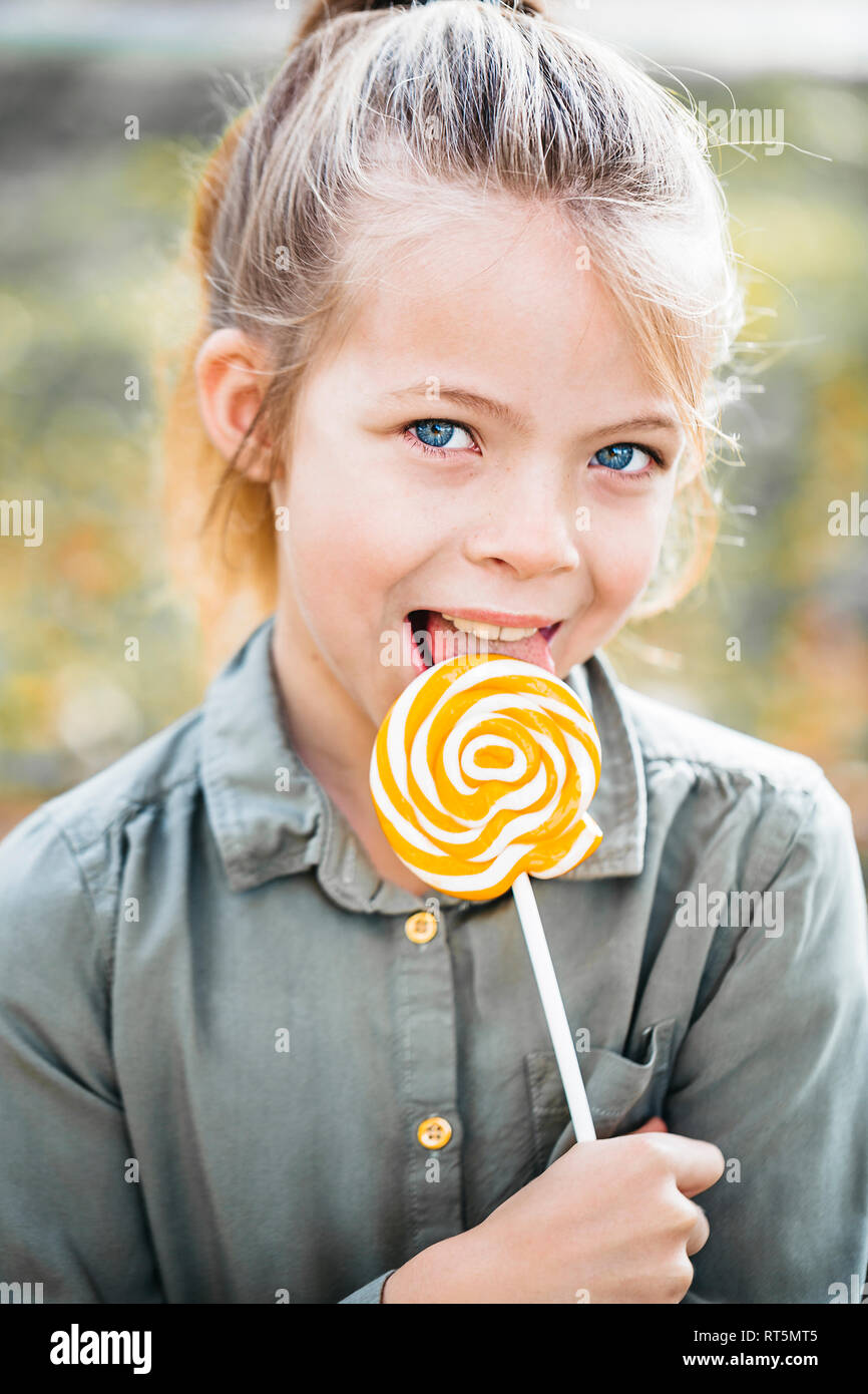 Portrait of girl licking lollipop Stock Photo
