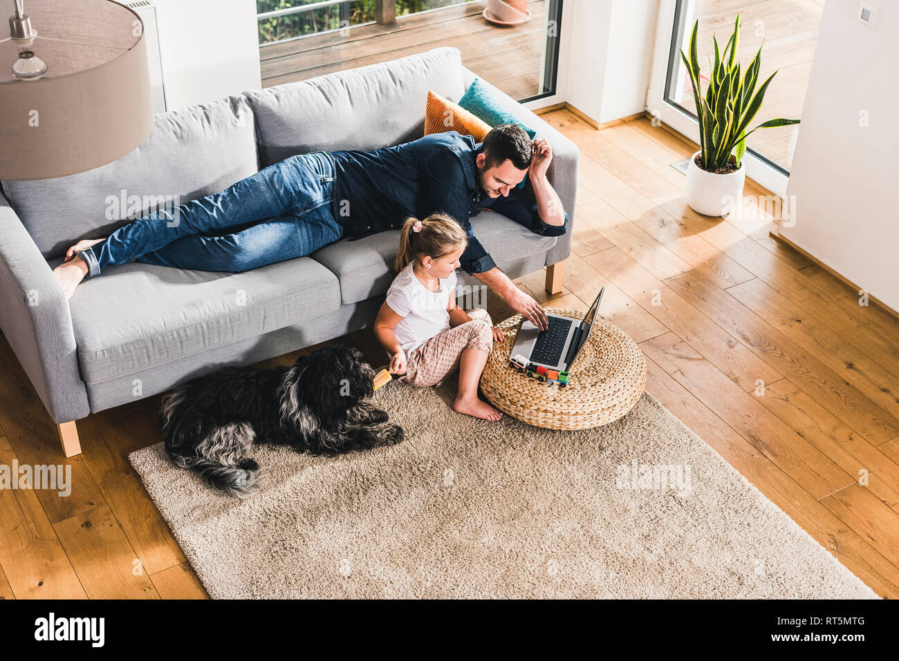 Father using laptop at home with his little daughter Stock Photo - Alamy