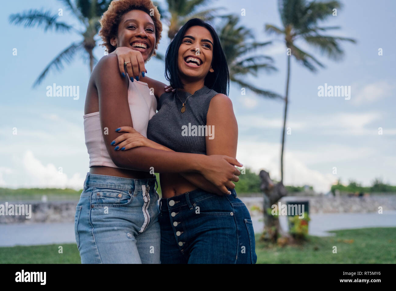 Two happy female friends hugging in a park Stock Photo