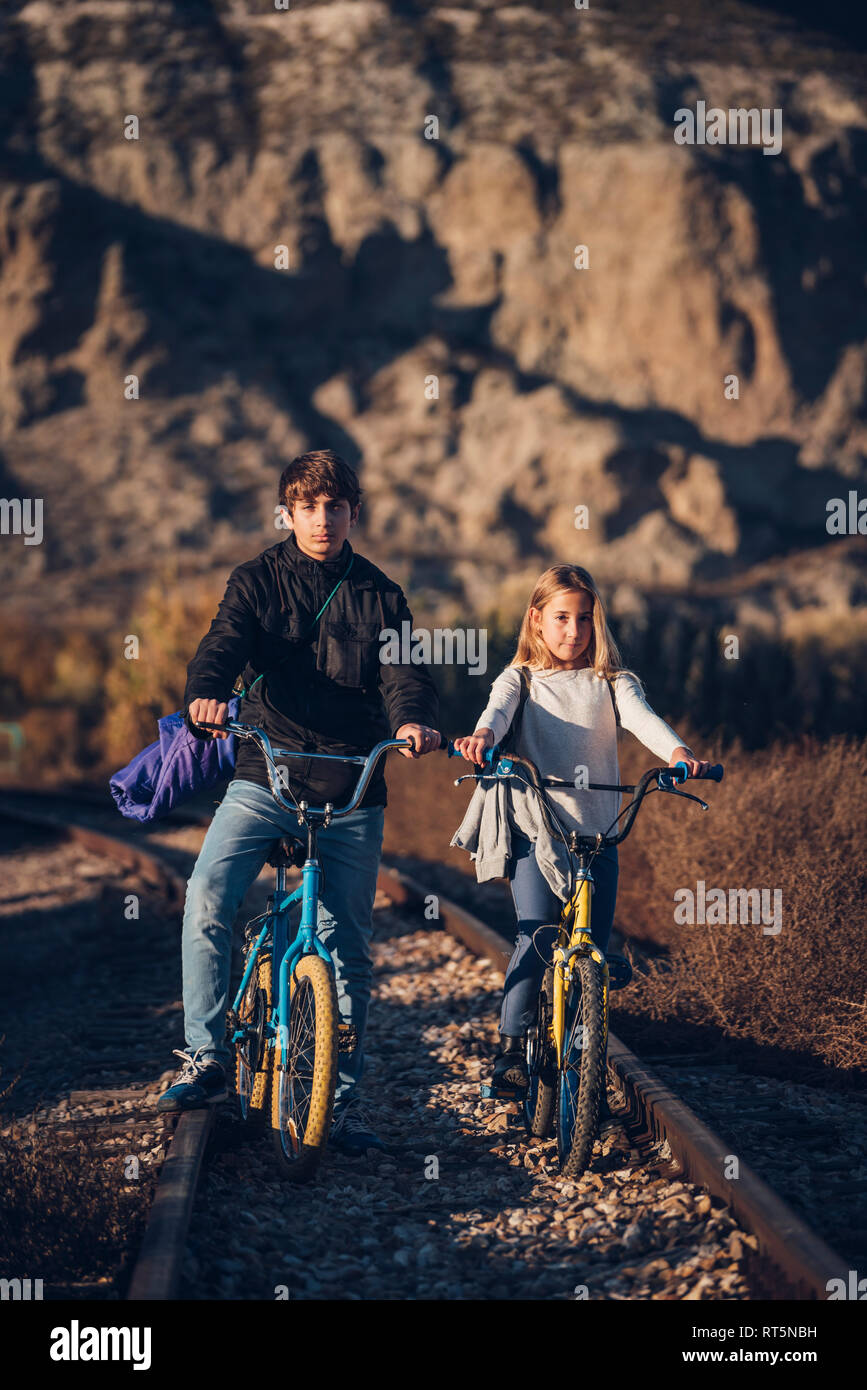 Boy and girl on the train track with bicycles Stock Photo