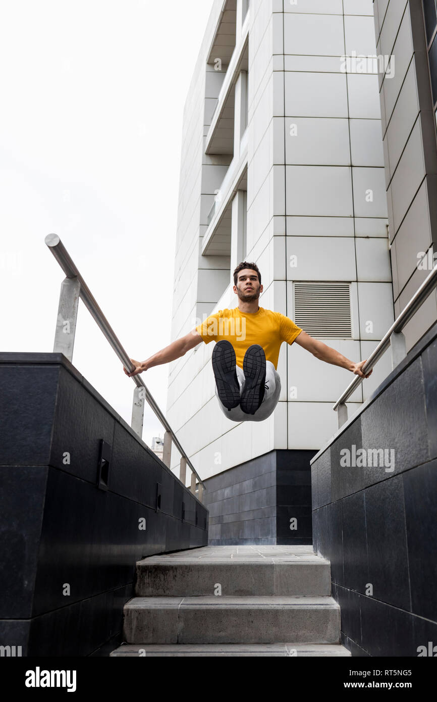 Young man during workout, between railing Stock Photo - Alamy