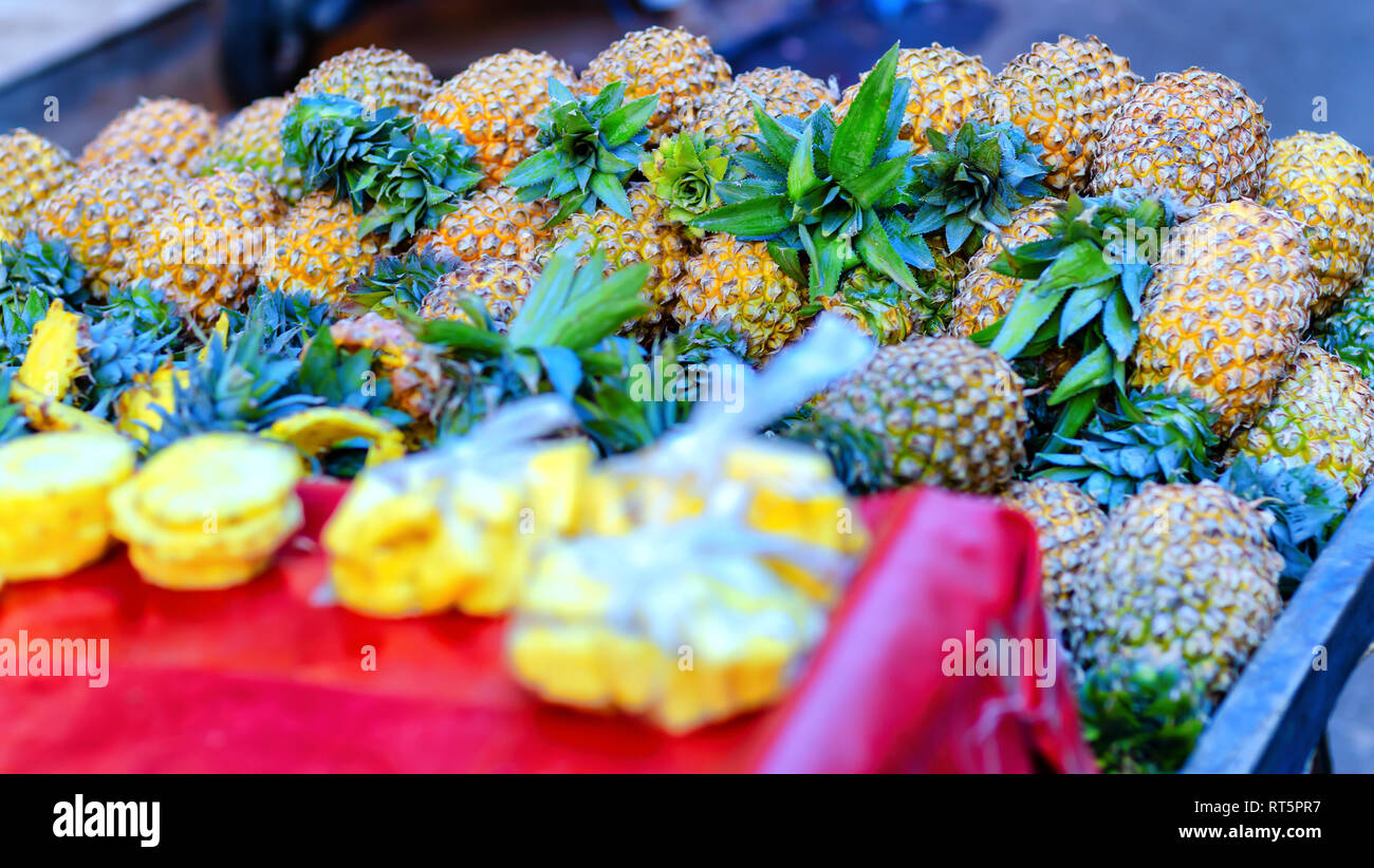 A close up image of ripe juicy pineapples (Ananas comosus) for sale on a street hawker's cart in Hyderabad, Telangana, India. Stock Photo