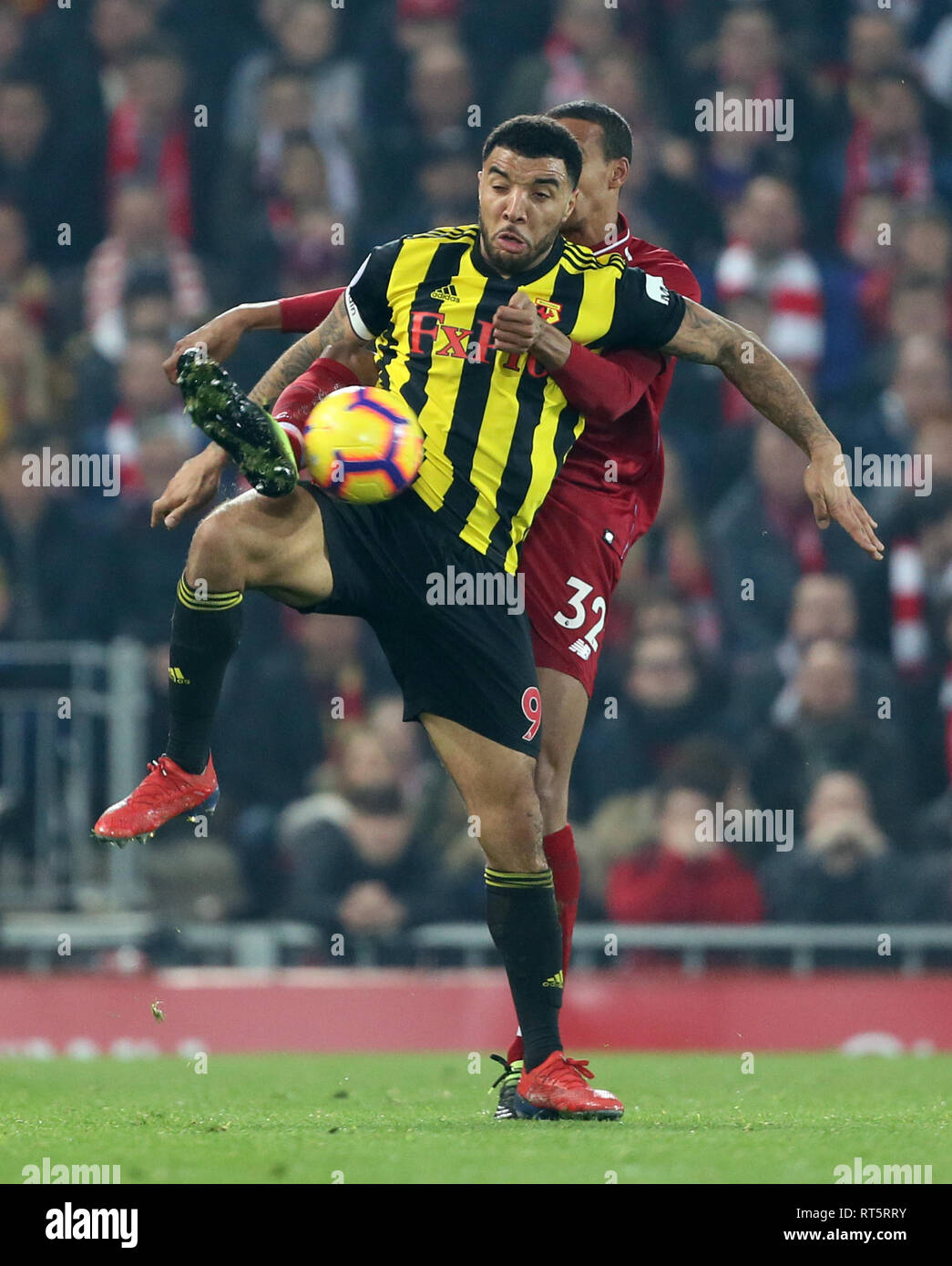 Watford's Troy Deeney and Liverpool's Joel Matip battle for the ball during the Premier League match at Anfield, Liverpool. Stock Photo