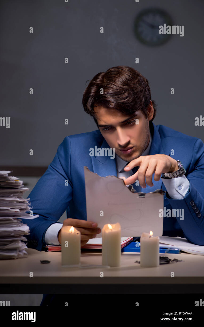 Businessman burning the evidence late in office Stock Photo - Alamy
