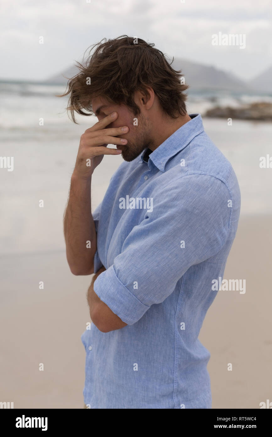 Worried man standing on the beach Stock Photo