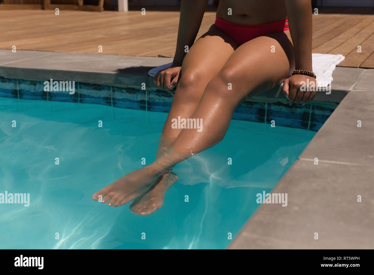 Woman relaxing in a swimming pool on a sunny day Stock Photo