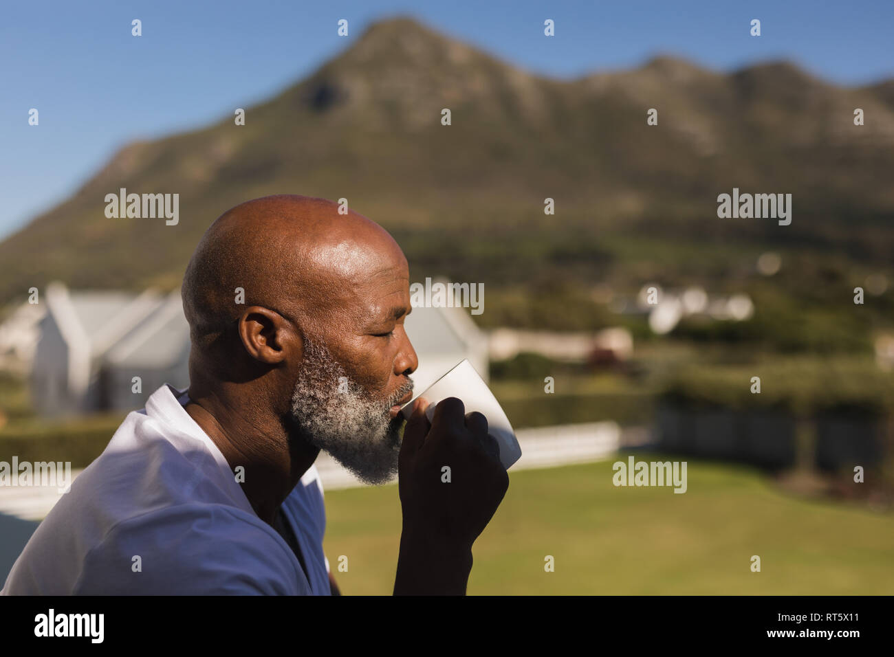 Senior man having coffee on the balcony Stock Photo
