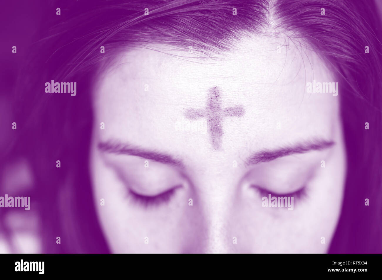 close up woman with cross on forehead in observance of Ash Wednesday with purple overlay Stock