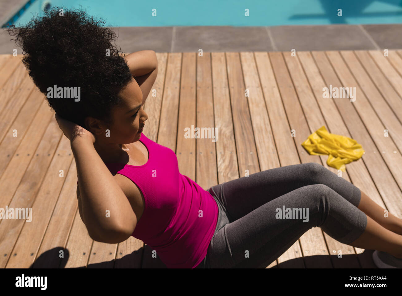 Woman performing crunch exercise in the backyard of home Stock Photo
