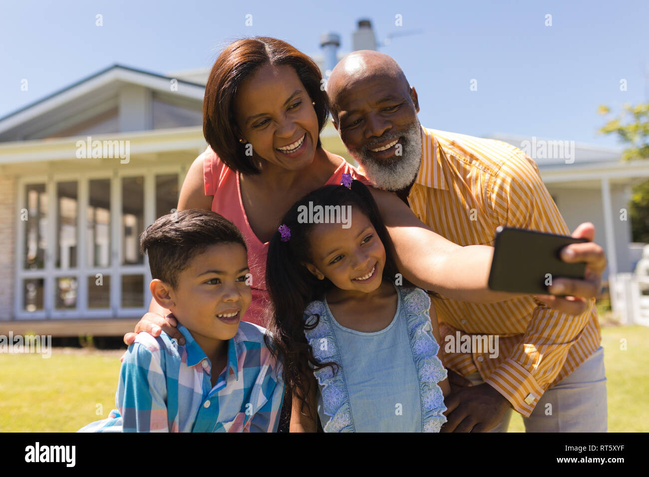 Multi-generation family taking selfie with mobile phone at the backyard Stock Photo