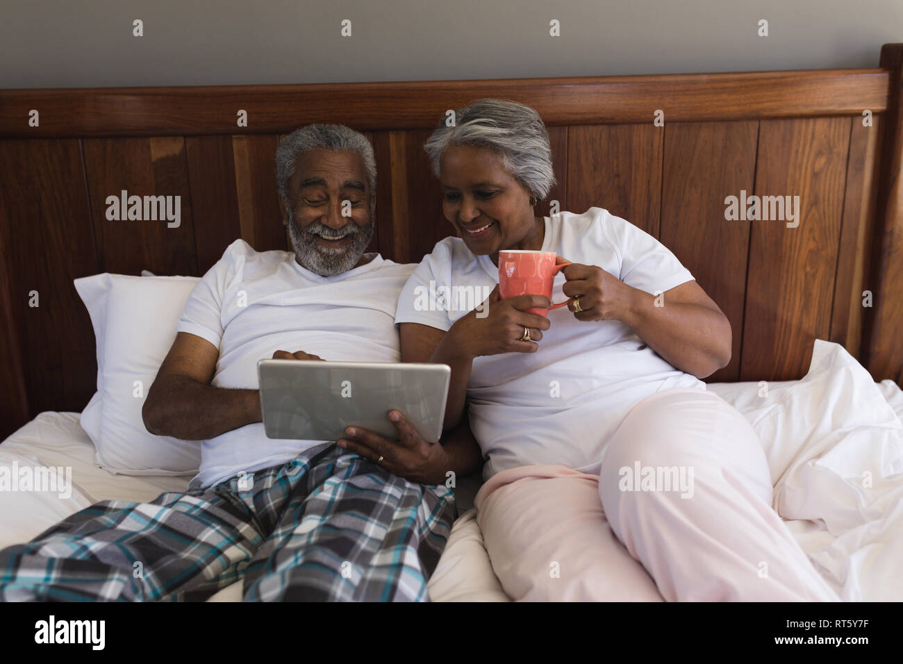 Senior couple using digital tablet in bedroom Stock Photo