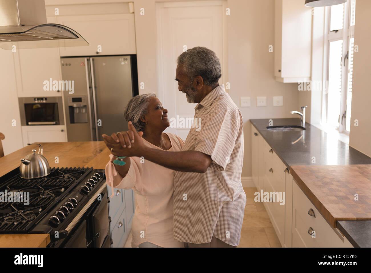 Senior couple dancing in a kitchen Stock Photo
