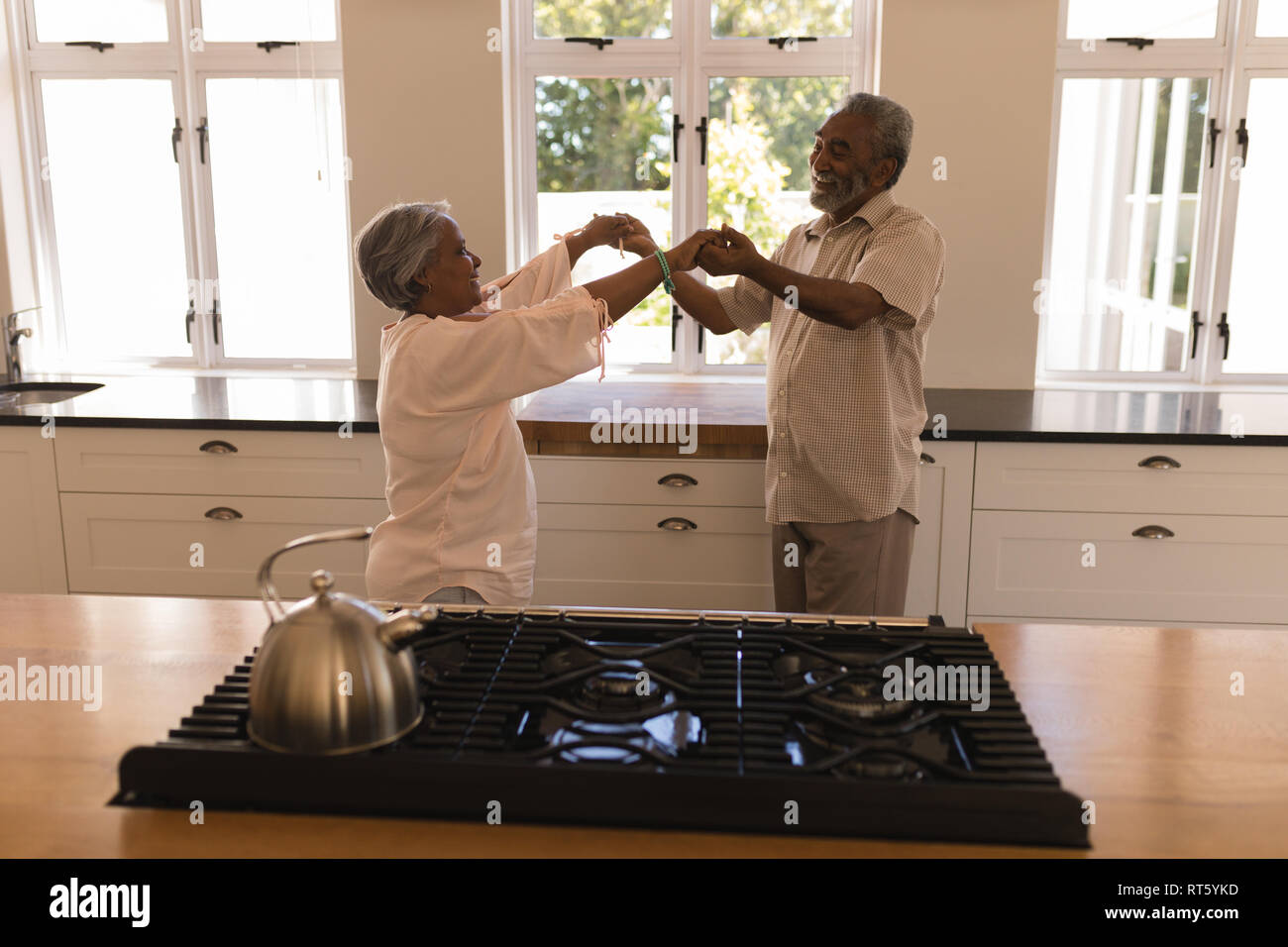 Senior couple dancing in a kitchen Stock Photo