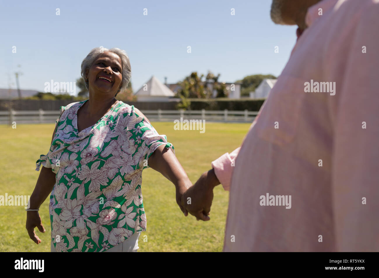 Senior couple walking hand in hand in the backyard Stock Photo - Alamy
