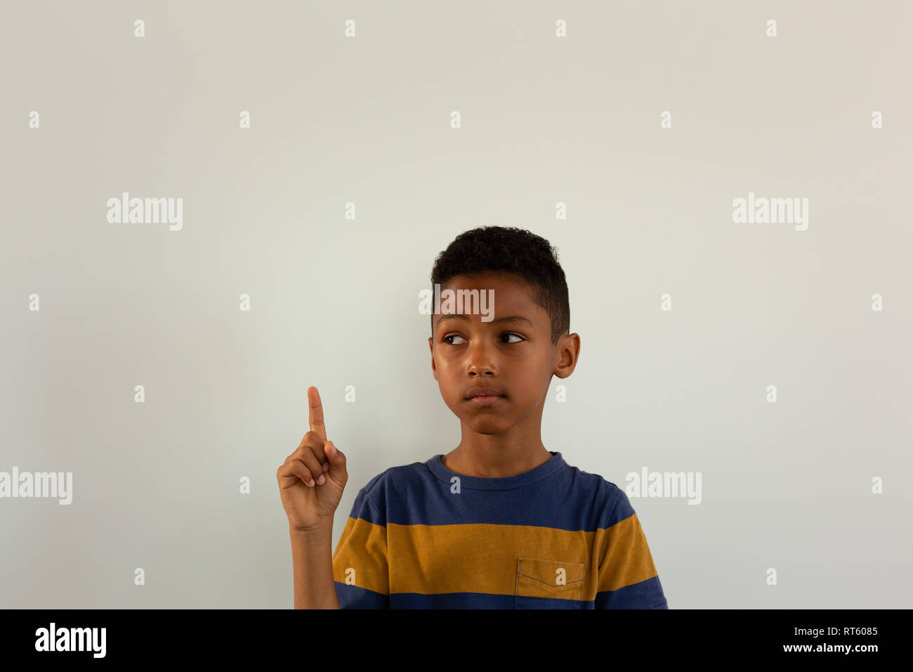 Thoughtful boy pointing his finger up Stock Photo