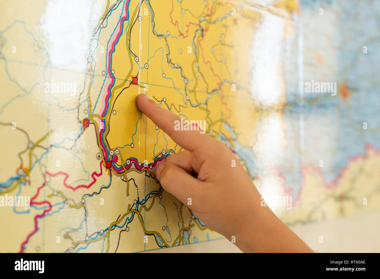 Boy pointing his finger on world map in a classroom Stock Photo