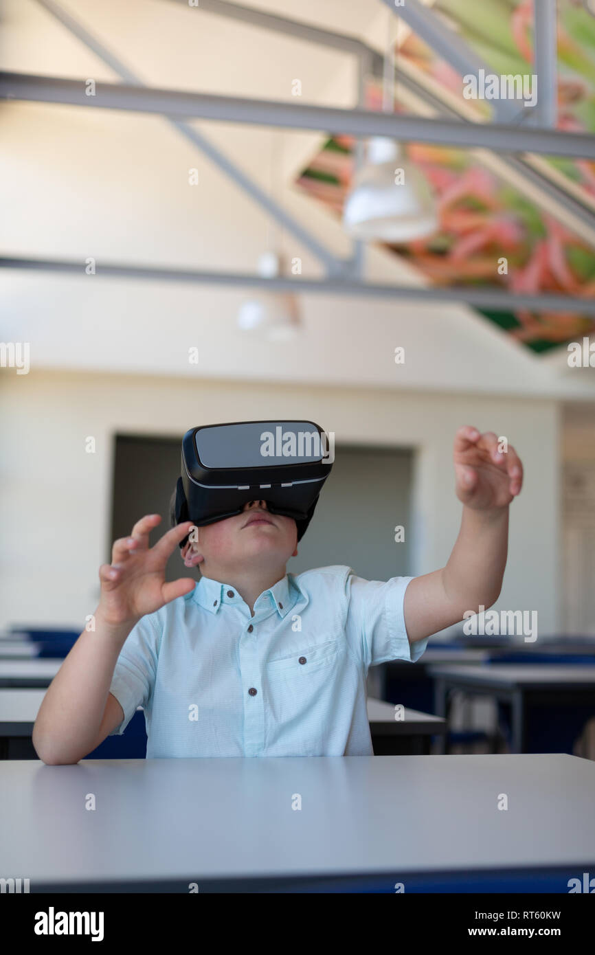 Schoolboy using virtual reality headset in a classroom Stock Photo