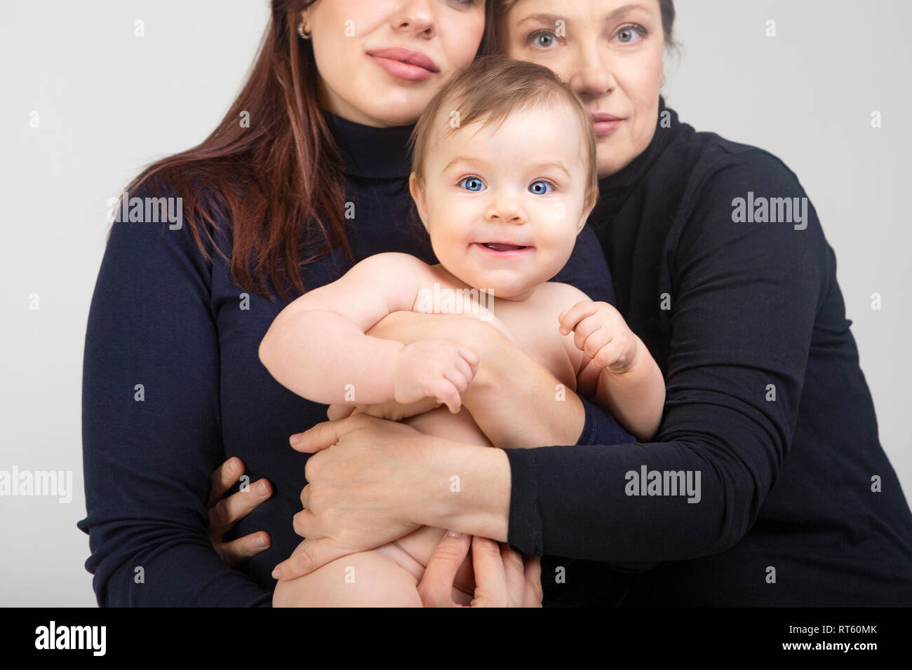 Grandmother, daughter and granddaughter on white portrait, happy family concept. Close up on the baby Stock Photo
