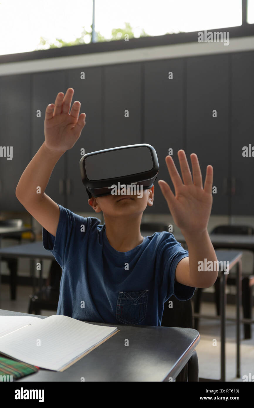 Schoolboy using virtual reality headset at desk in a classroom Stock ...