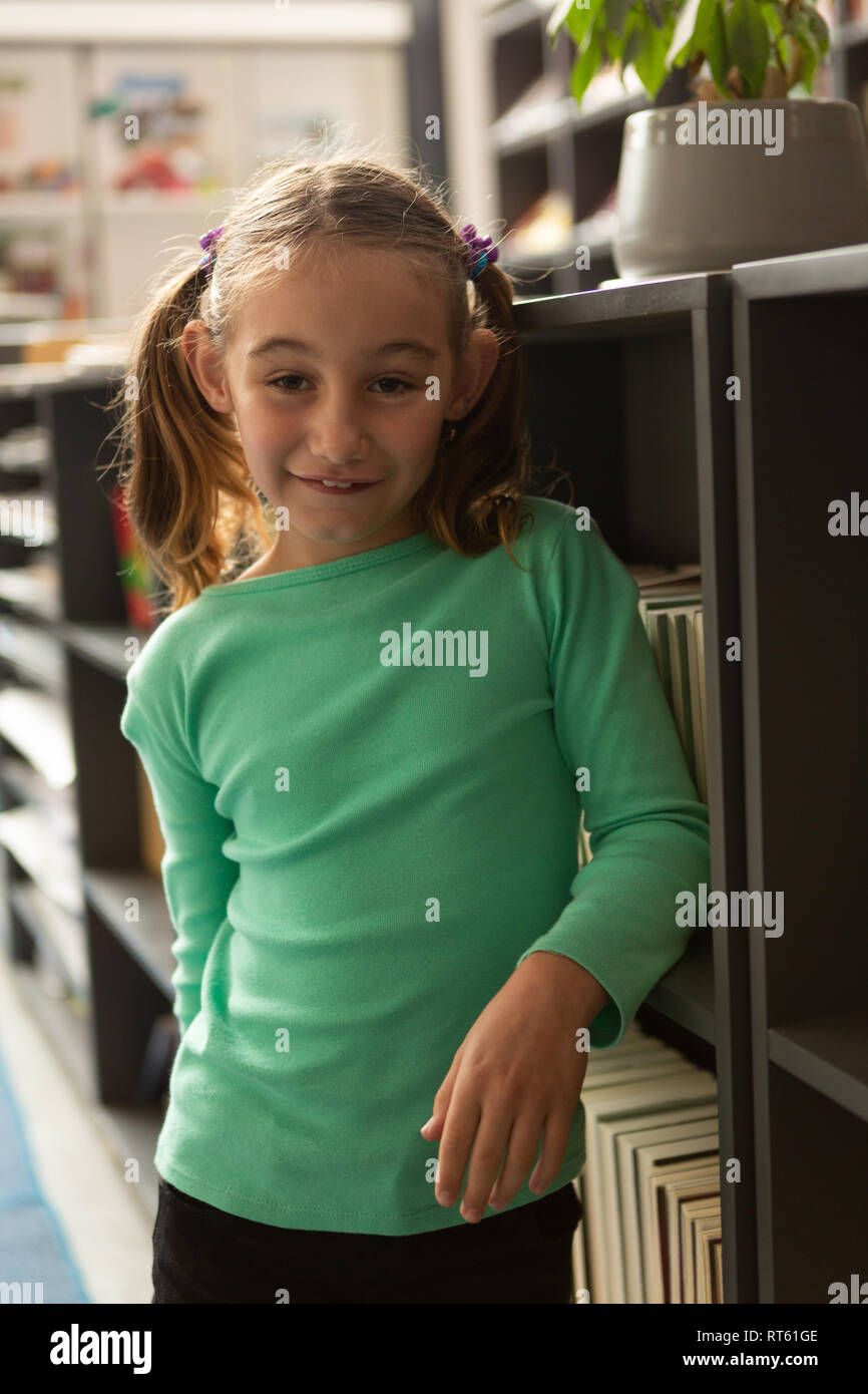 Smiling schoolgirl standing in library Stock Photo - Alamy