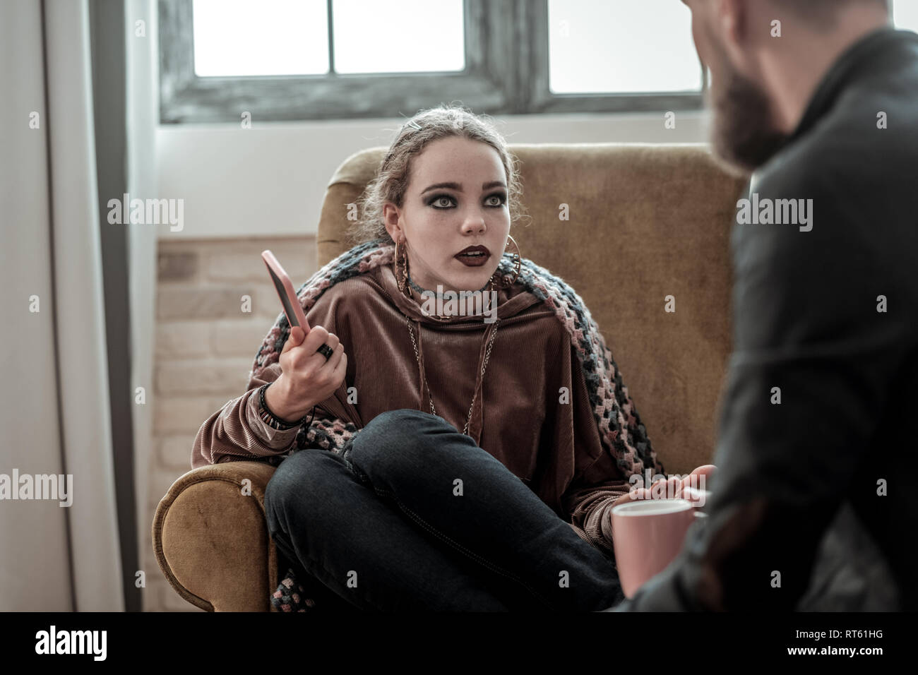 Nervous breakdown. Teenager with smoky eyes speaking with counselor after nervous breakdown Stock Photo